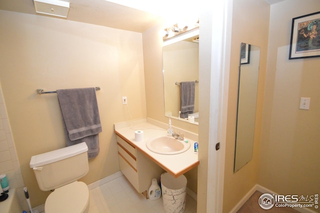 bathroom featuring vanity, toilet, and baseboards