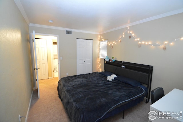 carpeted bedroom featuring visible vents, a closet, and ornamental molding