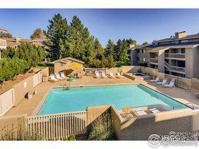 pool featuring an outbuilding, a patio, and fence