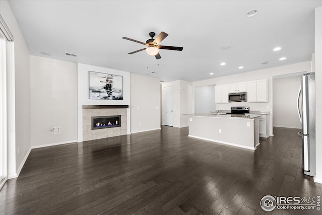 1604 Sorenson Dr, Windsor, CO 80550 - unfurnished living room with recessed lighting, a tile fireplace, ceiling fan, visible vents, and dark wood-style flooring