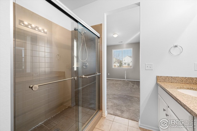 1604 Sorenson Dr, Windsor, CO 80550 - bathroom featuring baseboards, vanity, tile patterned flooring, and a shower stall