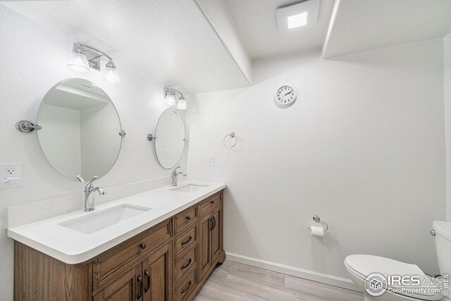 bathroom with vanity, hardwood / wood-style flooring, and toilet