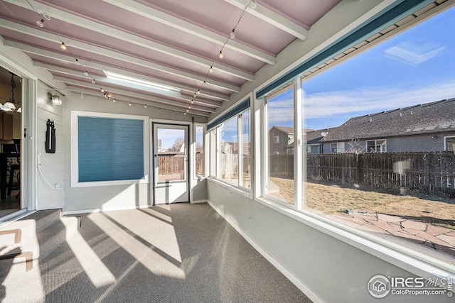 sunroom / solarium featuring lofted ceiling with beams