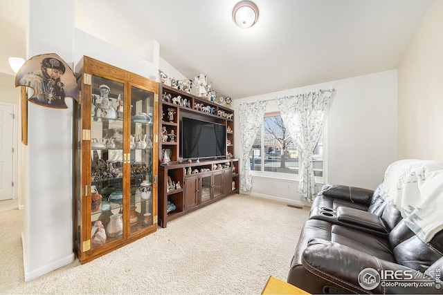 living room featuring carpet floors and vaulted ceiling