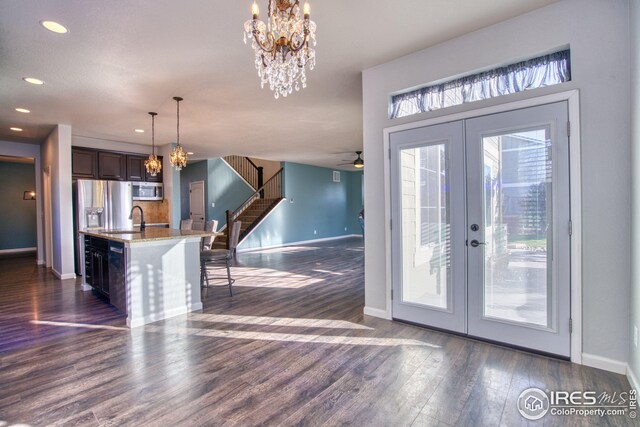 doorway to outside featuring french doors, dark wood-type flooring, ceiling fan with notable chandelier, and sink