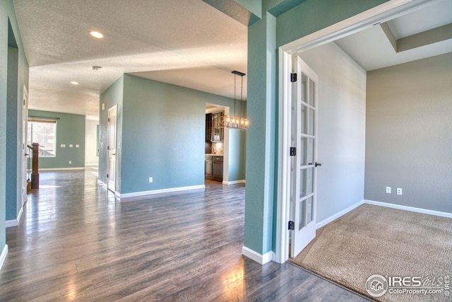 spare room with a textured ceiling and dark wood-type flooring