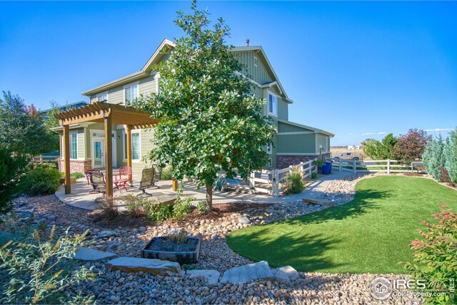 back of property featuring a yard, a pergola, and a patio