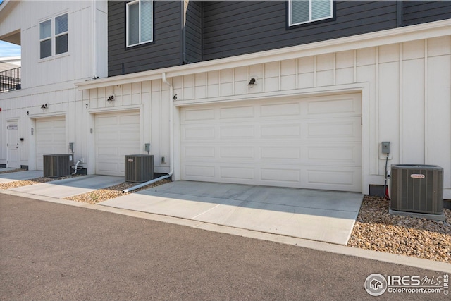 garage with concrete driveway and central air condition unit