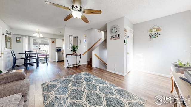 living room featuring a textured ceiling, ceiling fan with notable chandelier, and hardwood / wood-style flooring