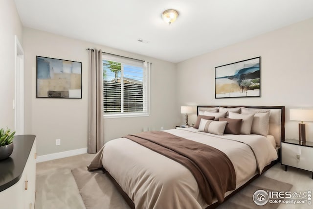 bedroom featuring light carpet, visible vents, and baseboards