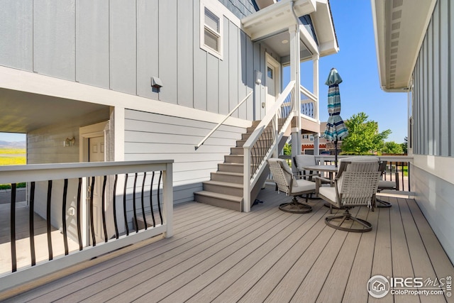wooden deck with stairway and outdoor dining space