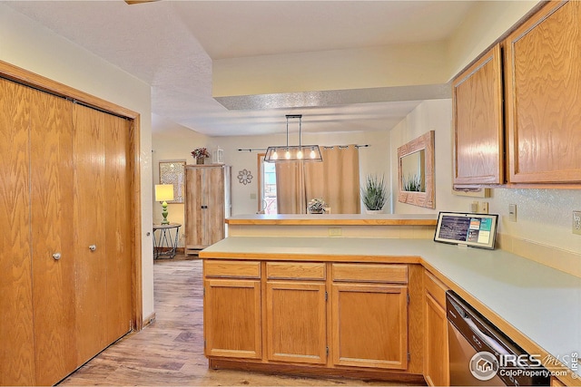 kitchen featuring decorative light fixtures, light hardwood / wood-style flooring, kitchen peninsula, and dishwasher