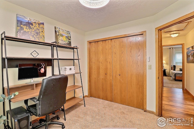 carpeted office with a textured ceiling