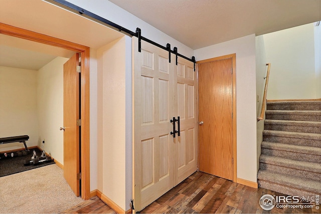 hall with dark hardwood / wood-style floors and a barn door