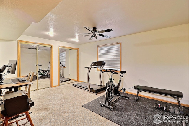 workout area with ceiling fan, carpet flooring, and a textured ceiling