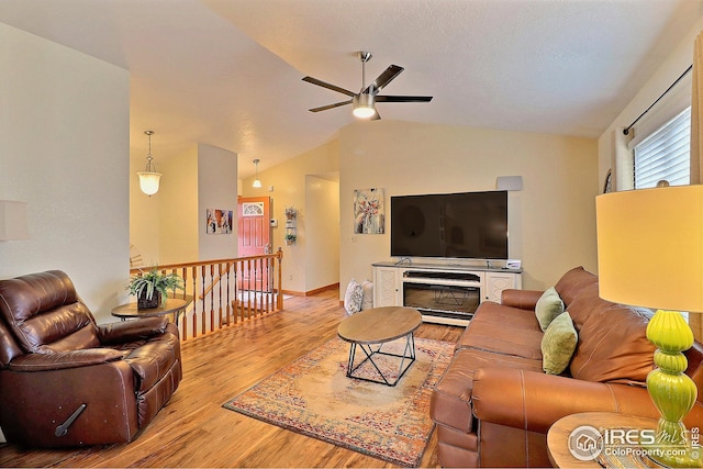 living room featuring lofted ceiling, ceiling fan, and light hardwood / wood-style flooring