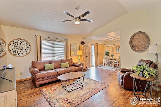 living room with lofted ceiling, hardwood / wood-style floors, a textured ceiling, and ceiling fan