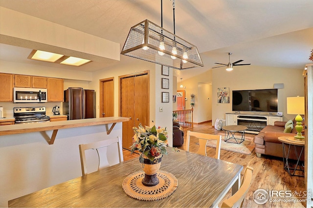 dining space with lofted ceiling, ceiling fan, and light hardwood / wood-style flooring