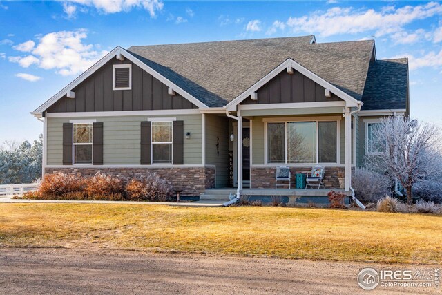 craftsman inspired home featuring a front lawn and covered porch