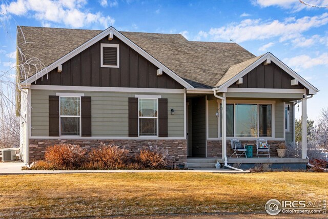 craftsman house with covered porch, central air condition unit, and a front yard