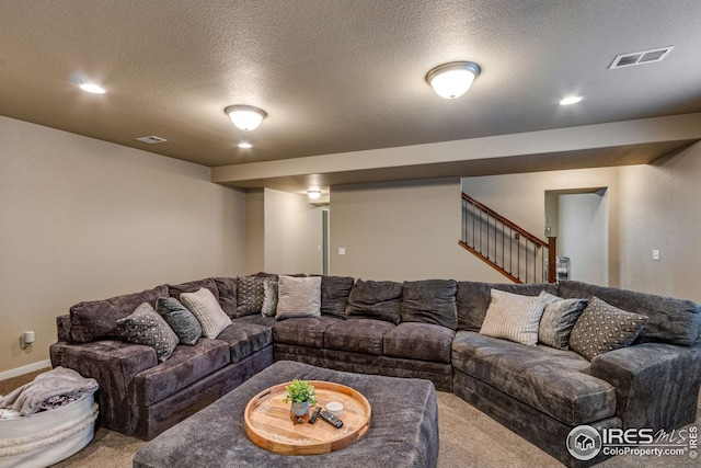 carpeted living room featuring a textured ceiling