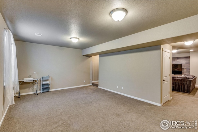 basement featuring carpet and a textured ceiling