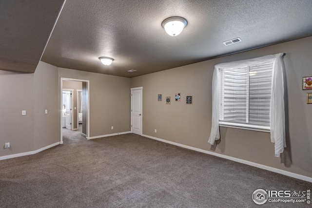 spare room featuring carpet flooring and a textured ceiling