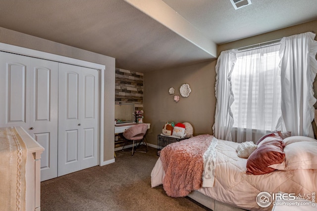 bedroom with a closet, carpet, and a textured ceiling