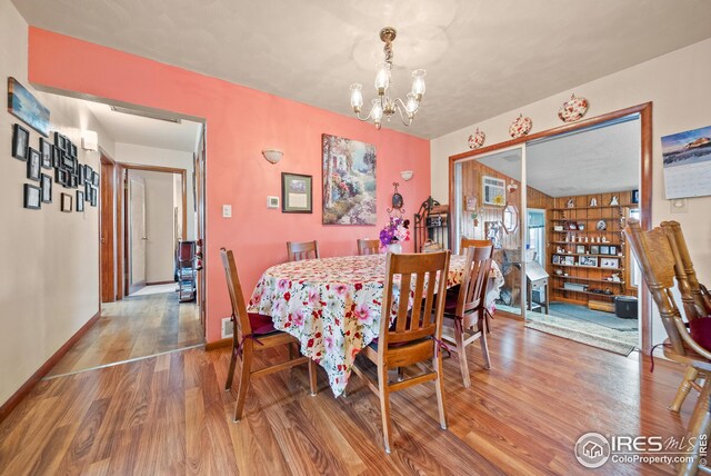 dining area featuring hardwood / wood-style flooring and a chandelier