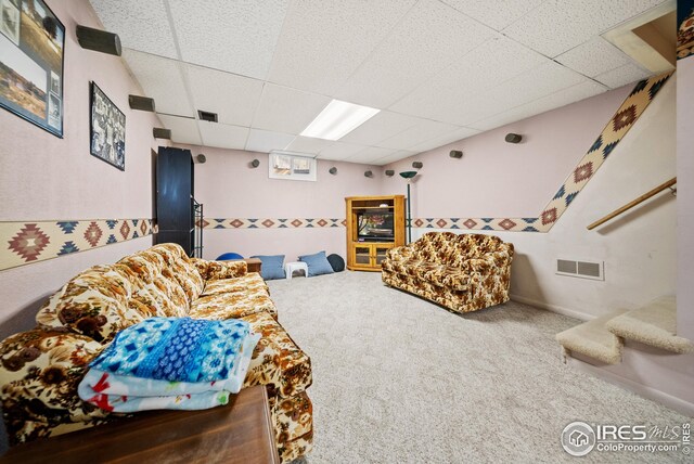 living room with a paneled ceiling and carpet floors