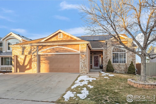 ranch-style home with brick siding, concrete driveway, a garage, and fence