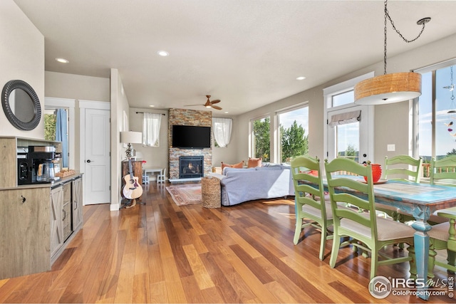 interior space with light wood-style floors, recessed lighting, ceiling fan, and a stone fireplace