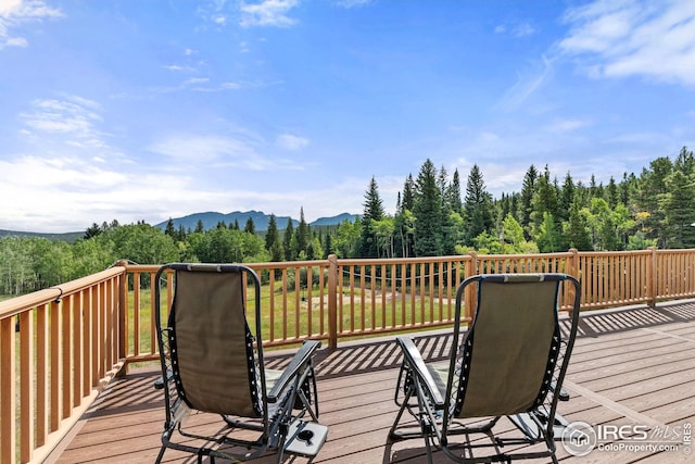 deck with a forest view and a mountain view