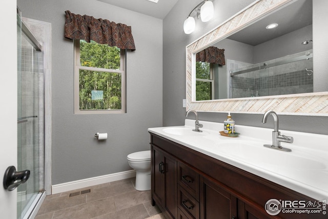 bathroom with baseboards, a shower stall, visible vents, and a sink