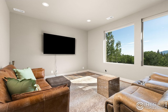 living area featuring baseboards, visible vents, wood finished floors, and recessed lighting