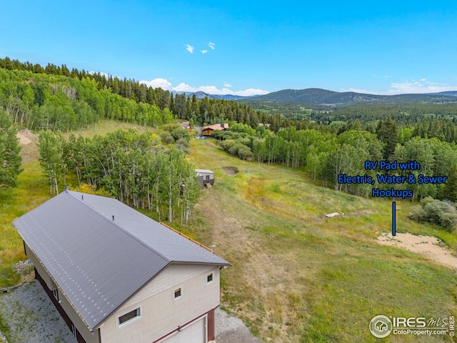 birds eye view of property featuring a mountain view and a view of trees