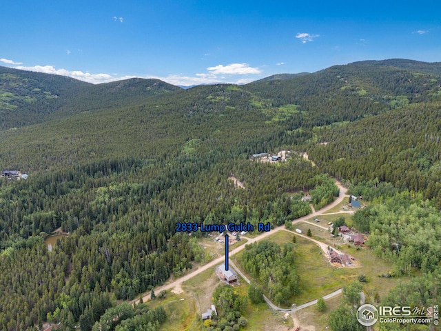 aerial view with a wooded view and a mountain view