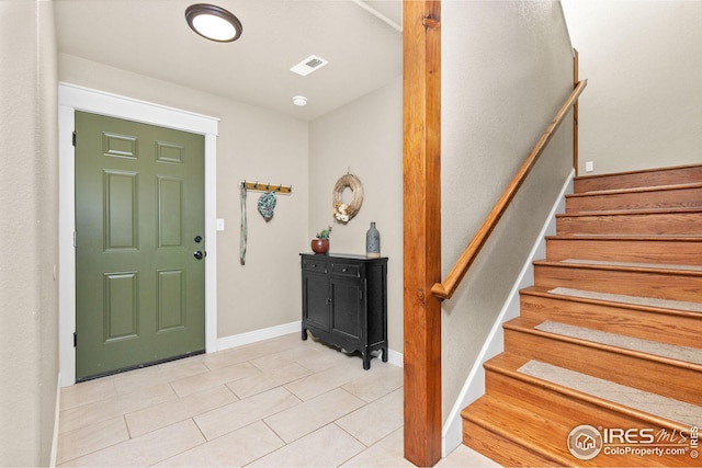 foyer featuring stairs, visible vents, and baseboards