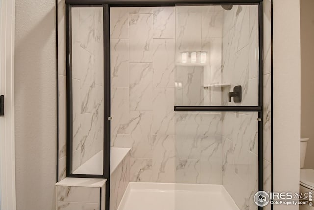 bathroom with walk in shower and toilet
