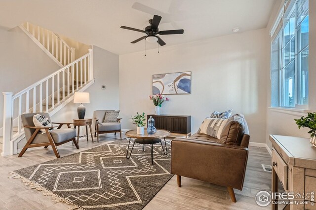 living area with ceiling fan, a healthy amount of sunlight, and wood-type flooring