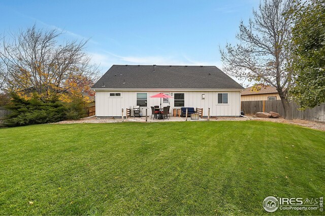 rear view of property featuring a patio and a lawn