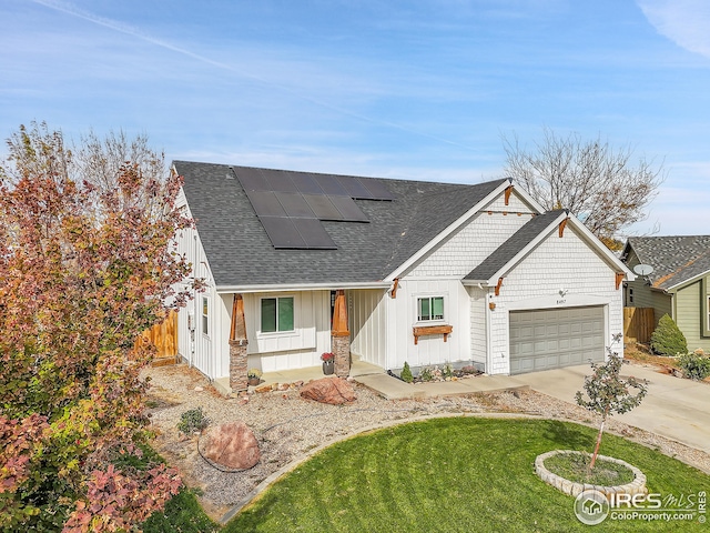 modern inspired farmhouse featuring solar panels, a garage, and a front lawn