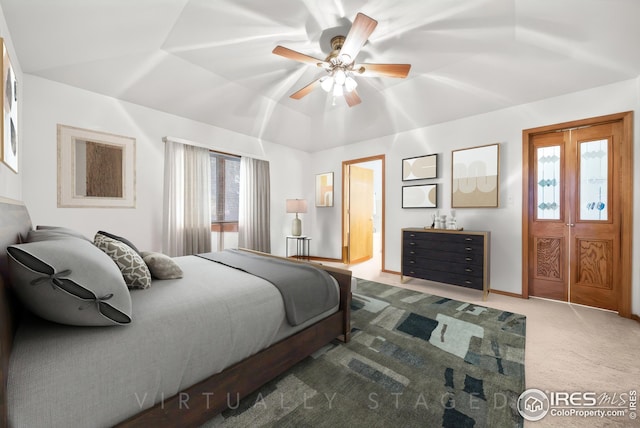 carpeted bedroom featuring lofted ceiling, ceiling fan, and a tray ceiling