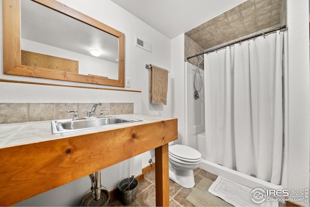 bathroom with a shower with shower curtain, toilet, and sink