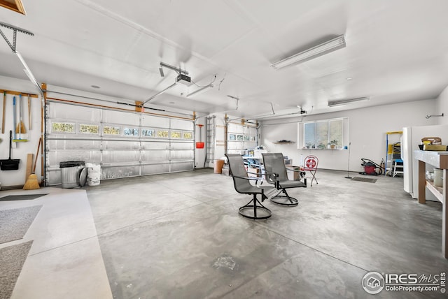 garage with a garage door opener and white fridge