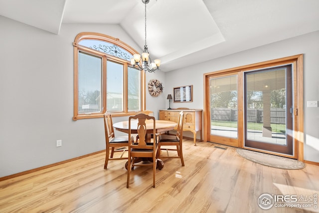 dining room with a chandelier, a wealth of natural light, and light wood-type flooring