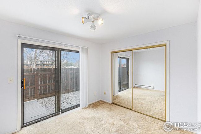 unfurnished bedroom featuring a baseboard heating unit, light carpet, access to outside, and a closet