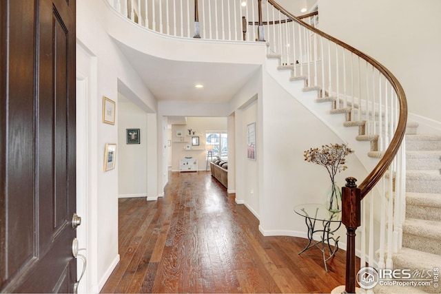 entryway with wood-type flooring and a high ceiling