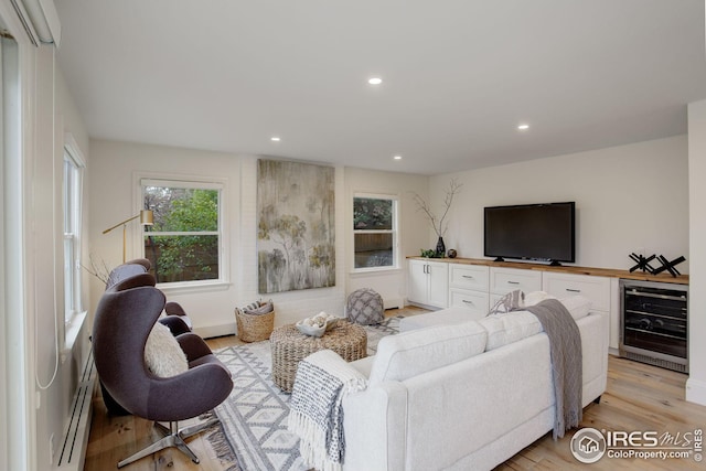 living room featuring light hardwood / wood-style floors, wine cooler, and a baseboard heating unit