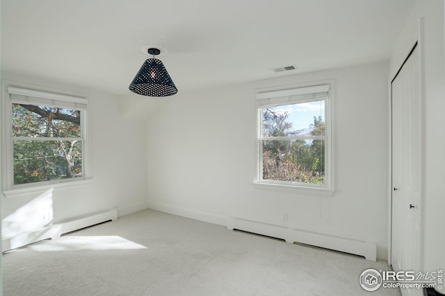 unfurnished bedroom with light carpet, a baseboard radiator, and a closet